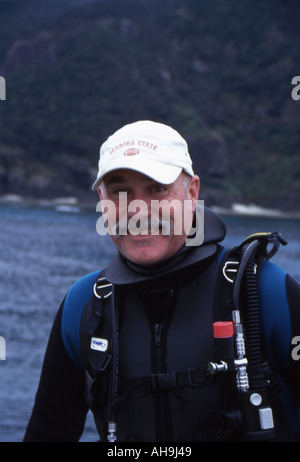 Tuffo dello Scuba Instructor si siede sul bordo della barca dopo l'immersione Foto Stock