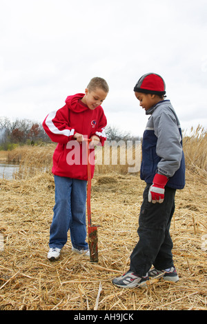 ILLINOIS Vernon Hills due ragazzi utilizzare spade per preparare un foro per la piantagione di alberi ambientali del progetto di restauro Foto Stock