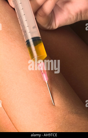 Mano che tiene la siringa Foto Stock