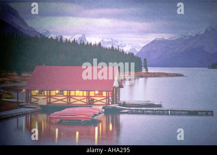 Canada Alberta Lago Maligne Curly Philips Boathouse Boathouse con canoe sul lago con le montagne al tramonto Foto Stock