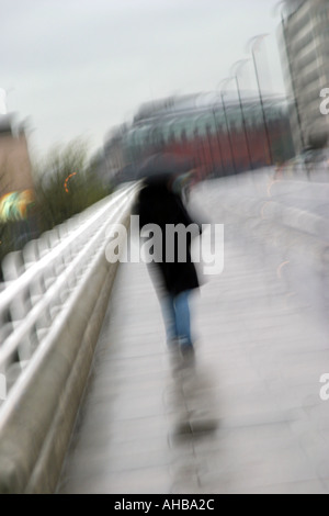 La figura camminando sotto la pioggia ponte di Waterloo a Londra Foto Stock