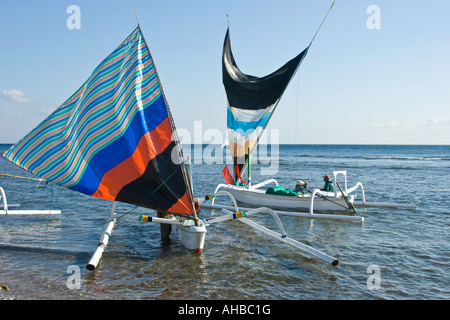 Jukung o Outrigger tradizionale la pesca in barca a vela di ritorno dal mare, Amed, Bali, Indonesia Foto Stock