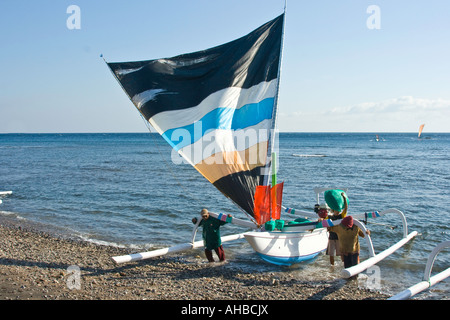 Jukung o Outrigger tradizionale la pesca in barca a vela di ritorno dal mare, Amed, Bali, Indonesia Foto Stock