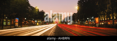 Champs Elysees il traffico con Arc De Triomphe al crepuscolo Foto Stock