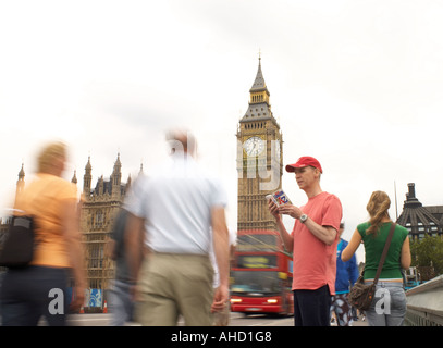 Perso cercando casualmente vestito uomo consulting dalla A alla Z Mappa sul Westminster Bridge davanti al Big Ben e le case del parlamento di Londra Foto Stock