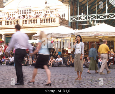 La donna da solo modello di rilascio questa persona solo sul telefono cellulare in Covent Garden di Londra si accoppia a piedi da Foto Stock