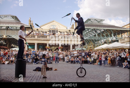 Artisti di strada giocoleria sul monociclo a Covent Garden di Londra al di fuori di Punch e Judy pub Foto Stock