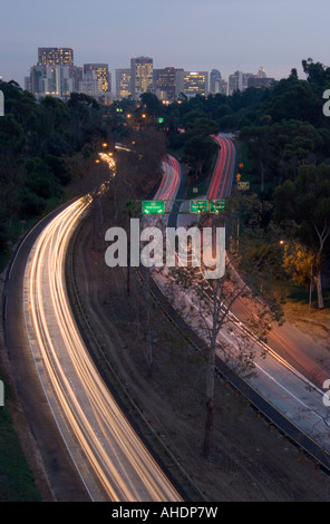 Una vista di una trafficata autostrada scattata di notte, portando alla San Diego skyline a distanza, Foto Stock