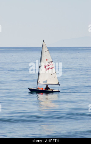 Piccola Vela dinghy becalmed in brezze leggere Foto Stock