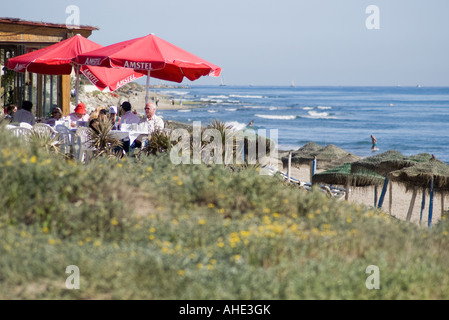 I clienti relax al sole invernale in una spiaggia da ristorante sulla Costa del, Spagna. Foto Stock