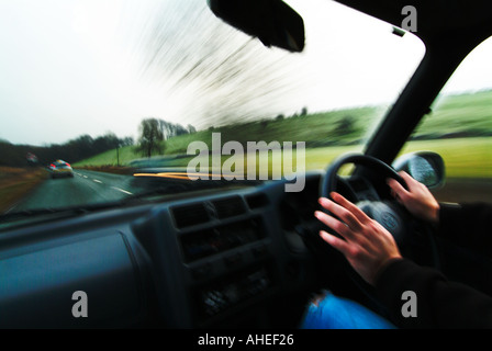 Driver le mani sul volante durante la guida attraverso il paese Foto Stock