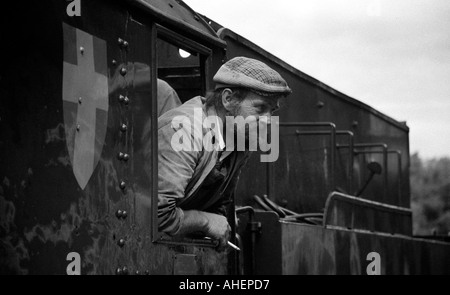 Motore a vapore conducente guardando fuori della cabina del locomotore su conserve di linea ferroviaria a Goathland nel North Yorkshire Foto Stock