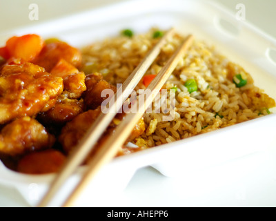 Cinese a prendere il cibo (General Tso's pollo e riso fritto) in bianco styrofoam con bacchette di bambù, Nello shallow focus. Foto Stock