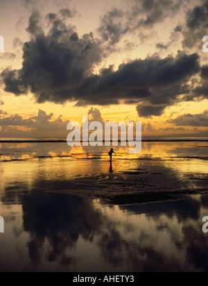 Cerca su acque calme a sunrise di silhouette del pescatore solitario off Sanur Beach sulla costa sud est Bali Indonesia Foto Stock