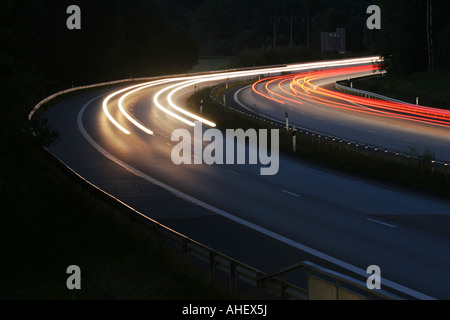 Sentieri di luce dalle automobili su una autostrada di notte Foto Stock