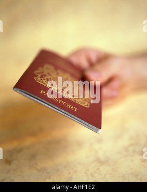 Mano che tiene il passaporto britannico Foto Stock