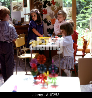 Un gruppo di bambini che giocano insieme a un tavolo interno in una scuola materna di Isola di Vancouver, British Columbia, Canada KATHY DEWITT Foto Stock