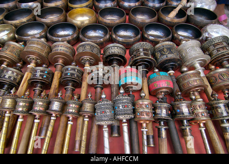 Nepalese e Tibetano artigianato comprese ruote della preghiera per la vendita su un mercato in stallo Kathmandu in Nepal Foto Stock