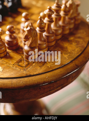 Close-up di legno intagliato pezzi di scacchi intarsiato sul tavolo antico Foto Stock
