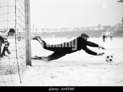 Calcio, Bundesliga, 1965/1966, Wedau Stadium di Duisburg, Meidericher SV versus VfB Stoccarda 5:2, scena del match, gioco sulla neve massa, salvare dal detentore Guenter Sawitzki (VfB), sinistra Michael Bella (MSV) Foto Stock