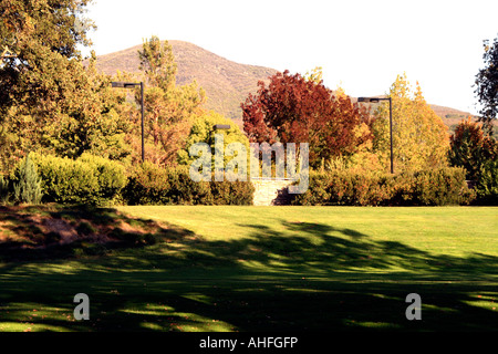 Campo da golf motivi su un pomeriggio autunnale con alberi e una montagna in background. Foto Stock