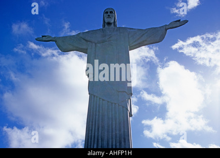 Cristo Redentore statua è raggiante contro un luminoso cielo blu e nuvole bianche, Corcovado Rio de Janeiro, Brasile Foto Stock