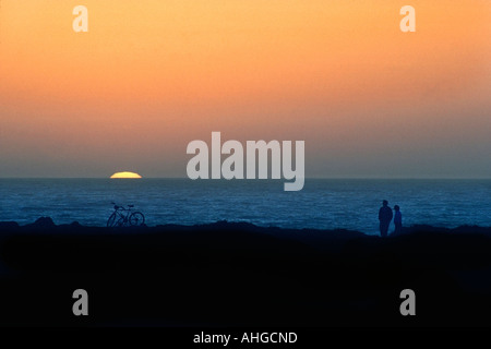 Nel complesso di un giovane in piedi accanto a loro biciclette lungo la costa con luminoso ambiente sun Foto Stock