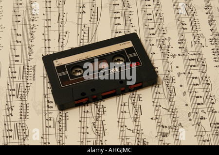 Un vecchio grungy musiccassette su un musicsheet Foto Stock