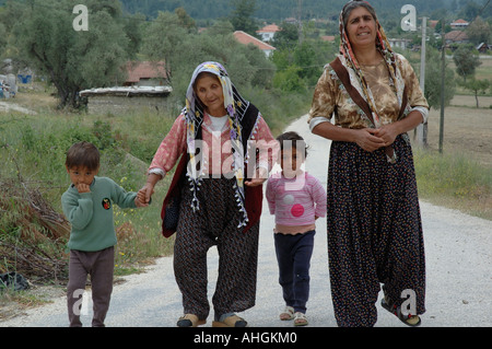 Nonna cieca essendo guidato da nipoti lungo la strada attraverso il piccolo villaggio di collina nella parte meridionale della Turchia. Foto Stock