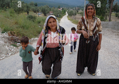 Nonna cieca essendo guidato da nipoti lungo la strada attraverso il piccolo villaggio di collina nella parte meridionale della Turchia. Foto Stock