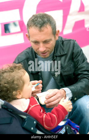 Parigi, FRANCIA - Ritratto "padre gay” che dà da mangiare a figlia, alla dimostrazione "pari diritti”. Attivismo LGBT, genitori LGBTQ+ gay padre e figlia Foto Stock