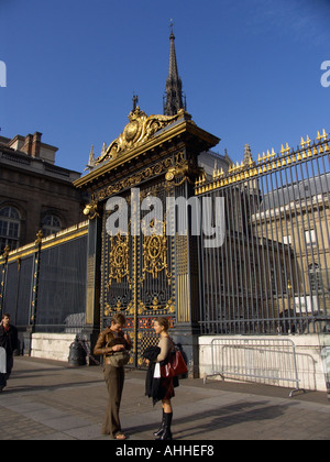 Due donne davanti alla porta di ornati a la Cour du Mai Palais de Justice telaio la guglia di Sainte Chapelle chiesa par Foto Stock