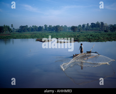INDONESIA Asia Sudorientale Lombok Timur NTB Praya uomo da pesca canoa outrigger mediante colata circolare net nel lago. Foto Stock