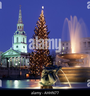 Water Feature in Trafalgar Square Londra Inghilterra UK e Christmas Tree Lights con fari a giorno sulle fontane e St Martin nella chiesa Fields e guglia Regno Unito Foto Stock