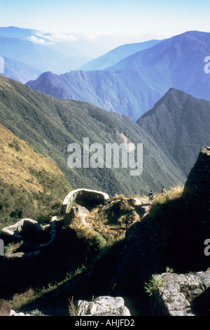 Vista lungo la ripida montagna fino alla rovina Inca a Phuyupatamarca con il sito Inti Pata dietro, attraverso la valle. Sentiero Inca, Perù. Foto Stock