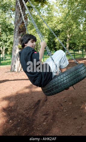 Adolescente basculante in un moto tireSwing dinamico movimento di oscillazione Oscillazione dinamica oscillante pneumatico Giochi Tempo libero di persone Foto Stock