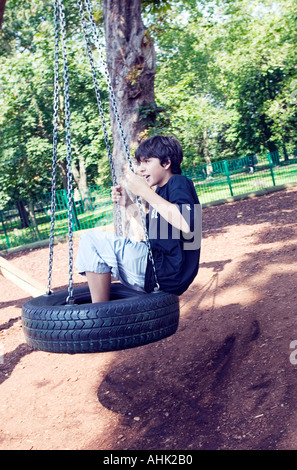 Adolescente basculante in una tireSwing movimento di oscillazione dinamica oscillante pneumatico Giochi Tempo libero persone adolescenti Teenag Foto Stock