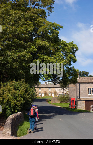 Gli escursionisti che arrivano nel villaggio di Downham in Oriente Lancashire Foto Stock