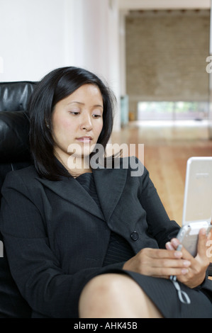 Ufficio moderno Asian imprenditrice mobile 30 30 40 40 40 50 asian business business donna cellulare sedia computer crepuscolo electron Foto Stock