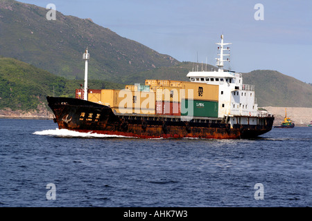 Nave cargo Freighter caricato con i contenitori di spedizione, Hong Kong, Cina Foto Stock