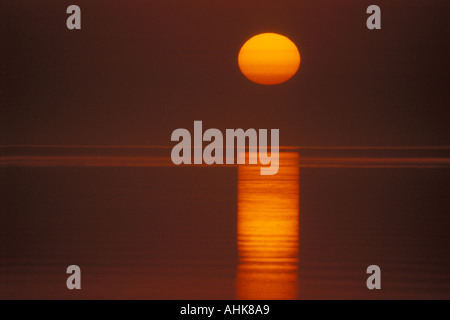 Grande sole tramontare sull acqua Foto Stock