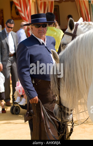 Annuale di feria de Sevilla, fiera di Siviglia. Uomo in costume tradizionale prendendo cura del suo cavallo durante la Feria de Abril, Fiera di Aprile Foto Stock