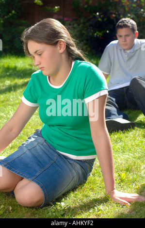 Coppia adolescenti seduti insieme nel parco avente un argomento e lotta Foto Stock