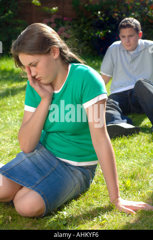 Coppia adolescenti seduti insieme nel parco avente un argomento e lotta Foto Stock