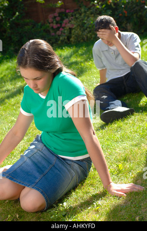 Coppia adolescenti seduti insieme nel parco avente un argomento e lotta Foto Stock