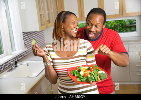 Coppia africano con piastra di vegetali in cucina Foto Stock