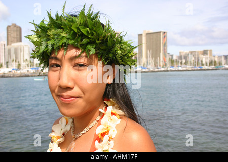 Giovane donna Hawaiana con haku lei e Waikiki in background Foto Stock