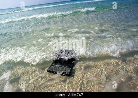 Computer portatile in oceano onde Foto Stock