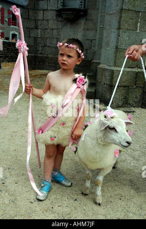 4-anno-vecchio Hugo e sue pecorelle attendere per entrare in chiesa per l annuale perdono, festa religiosa, nel suo villaggio bretone Foto Stock