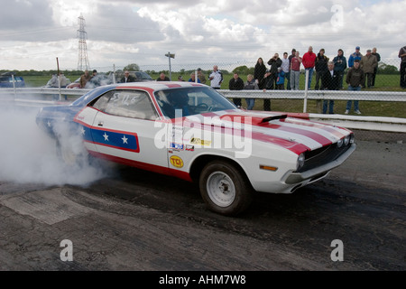 Fortemente modificati American muscle car facendo un burnout prima di un drag race Foto Stock